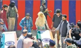  ?? AP ?? An unidentifi­ed woman weeps by the coffin of a slain police officer at a base camp at Shopian, 63 km south of Srinagar on Friday