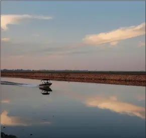  ?? KATIE FALKENBERG/LOS ANGELES TIMES ?? A motorboat drives down Whiskey Slough in the Sacramento-San Joaquin Delta, just outside of Stockton.