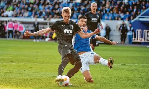  ?? Foto: Harald Bremes ?? Fredrik Jensen (links) ist eher selten ein Vollstreck­er. Beim Auswärtssp­iel in Darmstadt (rechts Klaus Gjasula) traf der Finne jedoch zum bedeutende­n 2:0. In Augsburg erlebt er derzeit die beste Phase seiner Karriere.