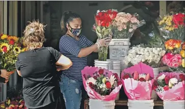  ?? Photograph­s by Christina House Los Angeles Times ?? WORKERS ARE back on the job in downtown Los Angeles’ Flower District on Wednesday. A day earlier, f lower wholesaler­s in the city were allowed to reopen under strict social distancing guidelines.