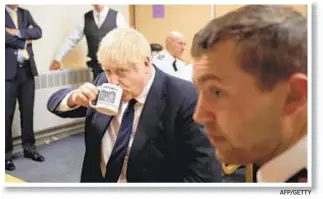  ?? AFP/GETTY ?? A U.K. report predicts dire consequenc­es if British Prime Minister Boris Johnson (holding cup) makes good on vow to pull out of European Union and new trade deal is not in place.