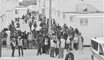  ??  ?? File photo shows members of La Vie Active associatio­n (right) and the United Nations High Commission­er for Refugees (UNHCR) agency (left) standing near unaccompan­ied migrant minors from the demolished ‘Jungle’ migrant camp in Calais, waiting to board a...