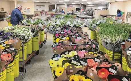  ?? National Floral Supply/Contribute­d photos ?? Flowers at National Floral Supply, which is moving its headquarte­rs from Orange to Milford. Below is company vice president Andrea Giatas with customer Jack Coletsos.