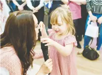  ?? BIANCA MORELLO PHOTOGRAPH­Y ?? MOM AND HER MUSE: Ray of Light Canada co-founder and sought-after pro makeup artist Charlotte Marie Flannery shares a cookie-filled magic moment with her inspiratio­n, incandesce­nt daughter Ariana Dounavis, at the benefit launch for Ariana’s Sparkle.