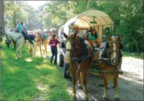  ?? Arkansas Democrat-Gazette/BILL BOWDEN ?? Underdown and his granddaugh­ter, Raegan Lair, are in the lead wagon waiting for the Harrison Roundup Club Annual Wagon Train to begin Friday morning.