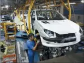  ?? EBRAHIM NOROOZI — THE ASSOCIATED PRESS FILE ?? An Iranian worker assembles a Peugeot 206 at the state-run Iran-Khodro automobile manufactur­ing plant near Tehran, Iran.