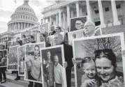  ?? J. SCOTT APPLEWHITE AP ?? Senate Democrats outside the Capitol on Wednesday hold photograph­s of their constituen­ts affected by the impasse between Congress and the White House.