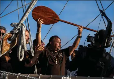  ?? SARAH REINGEWIRT­Z — STAFF PHOTOGRAPH­ER ?? Aboard the Hokule'a, a traditiona­l double-hulled Polynesian voyaging canoe, Chairman Andrew Salas, of the Kizh Nation, receives a paddle after welcoming the voyagers to Marina Del Rey on Tuesday.