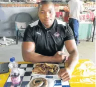  ?? Picture: SINESIPHO MBANDAZAYO ?? ROYAL FEAST: Lizo Gqoboka indulges in some braaied boerewors, pork and a bottle of Fanta grape