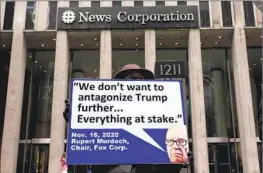  ?? Michael M. Santiago Getty Images ?? A PROTESTER takes aim at media boss Rupert Murdoch in New York last week. Dominion Voting Systems has a $1.6-billion defamation suit against Fox News.