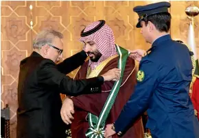  ?? AP ?? Pakistani President Arif Alvi, left, confers the nation’s highest civil award, the Nishan-e-Pakistan or Symbol of Pakistan, on Saudi Arabian Crown Prince Mohammed bin Salman at the presidenti­al palace in Islamabad.