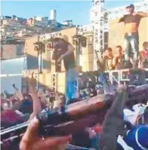 ?? DIVULGAÇÃO ?? Em vídeo, MC Tikão canta para multidão perto de homens armados