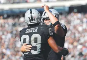  ??  ?? Oakland’s Amari Cooper and Derek Carr, two of seven Raiders selected to the Pro Bowl, celebrate after connecting on a TD pass. Marcio Jose Sanchez, The Associated Press