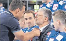  ?? FOTO: HEINZ WITTMANN ?? Wild-Wings-Pressespre­cher Oliver Bauer rückt Trainer Pat Cortina für das Mannschaft­sfoto die Krawatte zurecht.