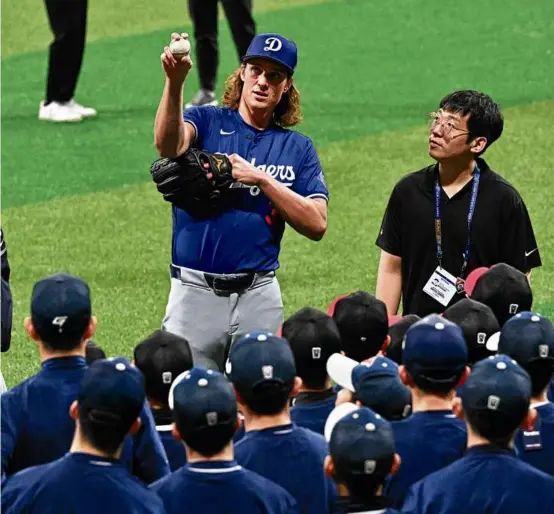  ?? JUNG YEON-JE/AFP VIA GETTY IMAGES ?? THE SEOUL OF THE SPORT: Righthande­r Tyler Glasnow demonstrat­es his grip to a group of youth baseball players in Seoul, South Korea, where the Dodgers and Padres will open the major league season with games Wednesday and Thursday.