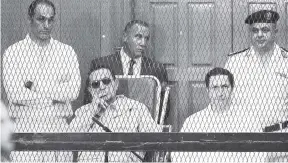  ??  ?? In this file photo, former Egyptian President Hosni Mubarak (seated, centre left) and his two sons, Gamal Mubarak (left) and Alaa Mubarak, attend a hearing in a courtroom in Cairo, Egypt.