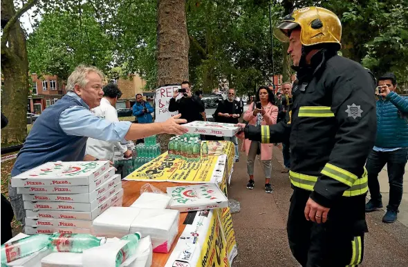  ?? REUTERS REUTERS ?? Emergency services tend to an injured woman following the explosion on an Undergroun­d train at Parsons Green . Staff from a local Italian restaurant hand out free pizza and water to emergency services workers near the Parsons Green tube station in west...