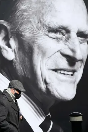  ?? Christophe­r Furlong/Getty Images ?? > A photograph in tribute to the Duke of Edinburgh on the window of Marks & Spencer in Windsor High Street