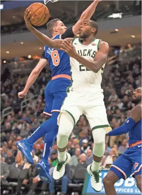  ?? JEFF HANISCH/USA TODAY ?? Khris Middleton of the Bucks ducks under the Knicks’ Mario Hezonja as he goes in for a reverse lay in during the second quarter.