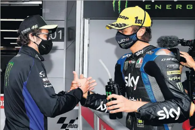  ??  ?? Valentino Rossi felicita a su hermanastr­o, Luca Marini, tras su victoria en la carrera de Moto2 del GP de Cataluña en el circuito de Montmeló, el 27 de septiembre de 2020.