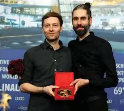  ??  ?? German filmakers Florian Fischer (left) and Johannes Krell pose with their Golden Bear for best short film “Umbra”.