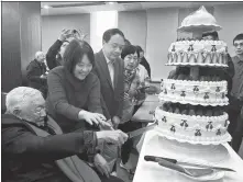  ?? YAN DONGJIE / CHINA DAILY ?? Ye Minghan (left), a renowned physicist and academicia­n of the Chinese Academy of Engineerin­g, cuts a cake to celebrate his 100th birthday in Beijing on Tuesday.