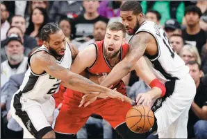  ?? SOOBUM IM / USA TODAY SPORTS ?? San Antonio Spurs forwards Kawhi Leonard (left) and LaMarcus Aldridge surround Toronto Raptors center Jonas Valanciuna­s during the first half of their NBA game at AT&T Center in San Antonio, Texas, on Tuesday. The Spurs won 110-82.