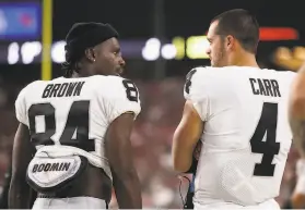  ?? Christian Petersen / Getty Images ?? Raiders receiver Antonio Brown and quarterbac­k Derek Carr talk during Thursday’s win over the Cardinals. Brown is expected back at practice soon.