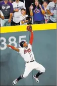  ?? John Bazemore ?? The Associated Press Braves left fielder Ronald AcunaJr. catches a ball hit by Manny Machado to end the top of the fifth inning in the Dodgers’ 6-5 loss Sunday at Suntrust Park.