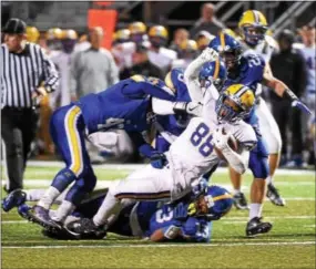  ?? PETE BANNAN — DIGITAL FIRST MEDIA ?? Downingtow­n East’s Stocker Brassir is tackled after a big gain against Downingtow­n West Friday.