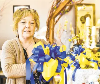  ?? THE MORNING CALL APRIL GAMIZ PHOTOS/ ?? Kathy Slane, owner of Michael Thomas Floral, makes blue-and-yellow ribbons as a show of solidarity and support for Ukraine on Friday in Allentown. She is giving the ribbons away for free.