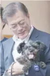  ?? — Reuters ?? South Korean President Moon Jaein welcomes a rescue dog to his official Blue House residence in Seoul on Wednesday.
