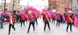  ?? ?? LEFT: Performers waving pink ribbons make their way down the street.