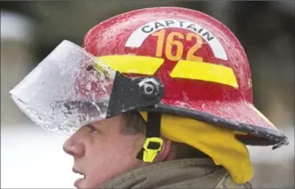  ??  ?? Cold temperatur­es created a shell of ice on a figherfigh­ter’s helmet at a house fire on Westmount Road West on Saturday.