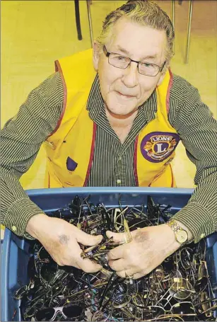  ?? ANCELENE MACKINNON/TC MEDIA ?? St. Eleanor’s Lions Club member Charlie Corkum sorts through one of the many boxes that contain close to 8,000 pairs of eyeglasses that will be shipped to those in need in Third World countries.