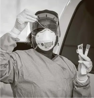  ?? Steve Gonzales / Staff photograph­er ?? Harris County public health nurse Harriett Lewis demonstrat­es her role at a testing site.