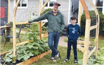  ??  ?? Sylvain Ward et son fils Sébastien ont construit un jardin avec des arches sur la pelouse devant leur maison. – Acadie Nouvelle: Alexandre Boudreau