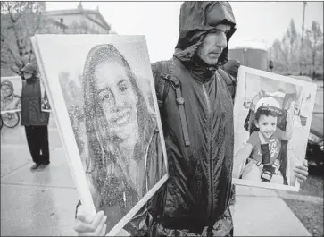  ?? Tannen Maury EPA/Shuttersto­ck ?? A MAN stands outside a Boeing shareholde­rs meeting in Chicago in April holding photos of people who died when two of the company’s 737 Max planes crashed. Boeing is reportedly facing an investigat­ion by the SEC.