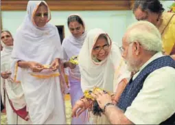  ??  ?? Vrindavan widows tying ‘Rakhi’ on the Prime Minister Narendra Modi’s wrist, on the occasion of Raksha Bandhan in New Delhi on Monday.