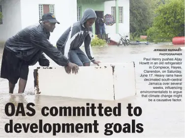  ?? JERMAINE BARNABY/ PHOTOGRAPH­ER ?? Paul Henry pushes Aljay Howitt in an old refrigerat­or in Cornpiece, Hayes, Clarendon, on Saturday, June 17. Heavy rains have decimated south-central Jamaica over several weeks, influencin­g environmen­talists to argue that climate change might be a...