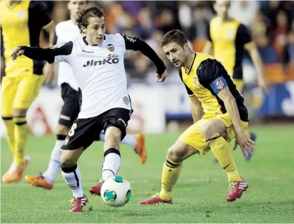  ??  ?? ANDRÉS Guardado, del Valencia (izquierda), maneja el balón ante Gabi Fernández, del Atlético de Madrid.