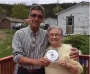  ?? THE CANADIAN PRESS ?? Wayne Chaulk presents Eleanor Parrott with a specially re-recorded copy of his band’s song “Carry Me.”