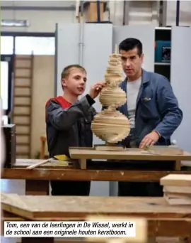  ??  ?? Tom, een van de leerlingen in De Wissel, werkt in de school aan een originele houten kerstboom.