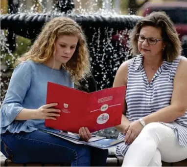  ?? ASSOCIATED PRESS ?? In this Friday, April 10, 2020, photo in Sanford, Fla., Serra Sowers, left, and her mother Ebru Ural look over brochures from various colleges. The coronaviru­s pandemic has changed the process of college visits to online and virtual interviews.