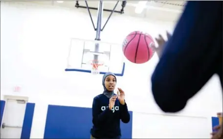  ?? THE NEW YORK TIMES JENN ACKERMAN/ ?? Nabhaii Farah, 12, plays basketball while wearing an Asiya hijab at a community centre in Minneapoli­s on December 31.