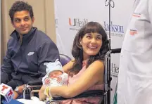  ?? PATRICK FARRELL/MIAMI HERALD ?? Maria Emilse Munoz Pena holds her newborn baby Santino as she smiles at Dr. Michael E. Ivan, who led a complex 12-hour surgery to remove two brain tumors that restored Maria’s sight.