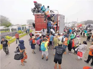  ?? MARCO UGARTE /ASSOCIATED PRESS ?? Migrants pack into the back of a trailer truck in Isla, Veracruz state, Mexico, on Sunday, as they begin their morning trek, hoping to reach the U.S. border.