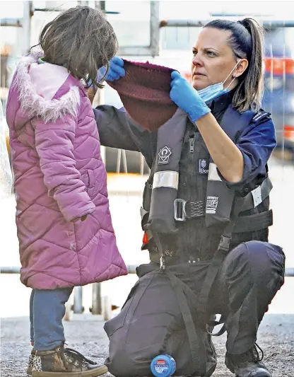  ?? ?? A young girl is helped by a Border Force officer as a group of migrants are brought into Dover, Kent, from a small boat in the Channel yesterday