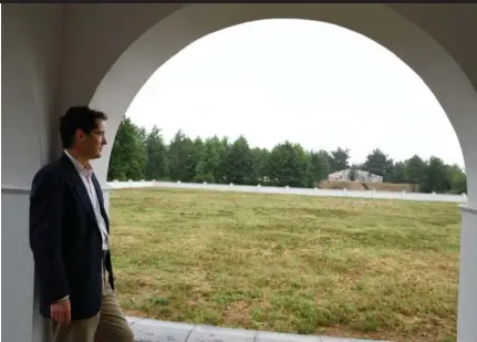  ??  ?? Martin Regg Cohn looks out at the field where thousands of Jews were slaughtere­d in his mother’s hometown of Rava Ruska, Ukraine, during the Second World War. In the distance, a monument made of Jewish headstones from an old cemetery marks the site.