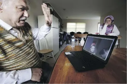  ?? MARTHA IRVINE/THE ASSOCIATED PRESS ?? Rifat Moustafa, a Syrian immigrant, greets his 16-year-old son, Hasib, during a video chat session at his home in Columbus, Ohio, as Hasib’s mother, Alizabet Yandem, looks on.